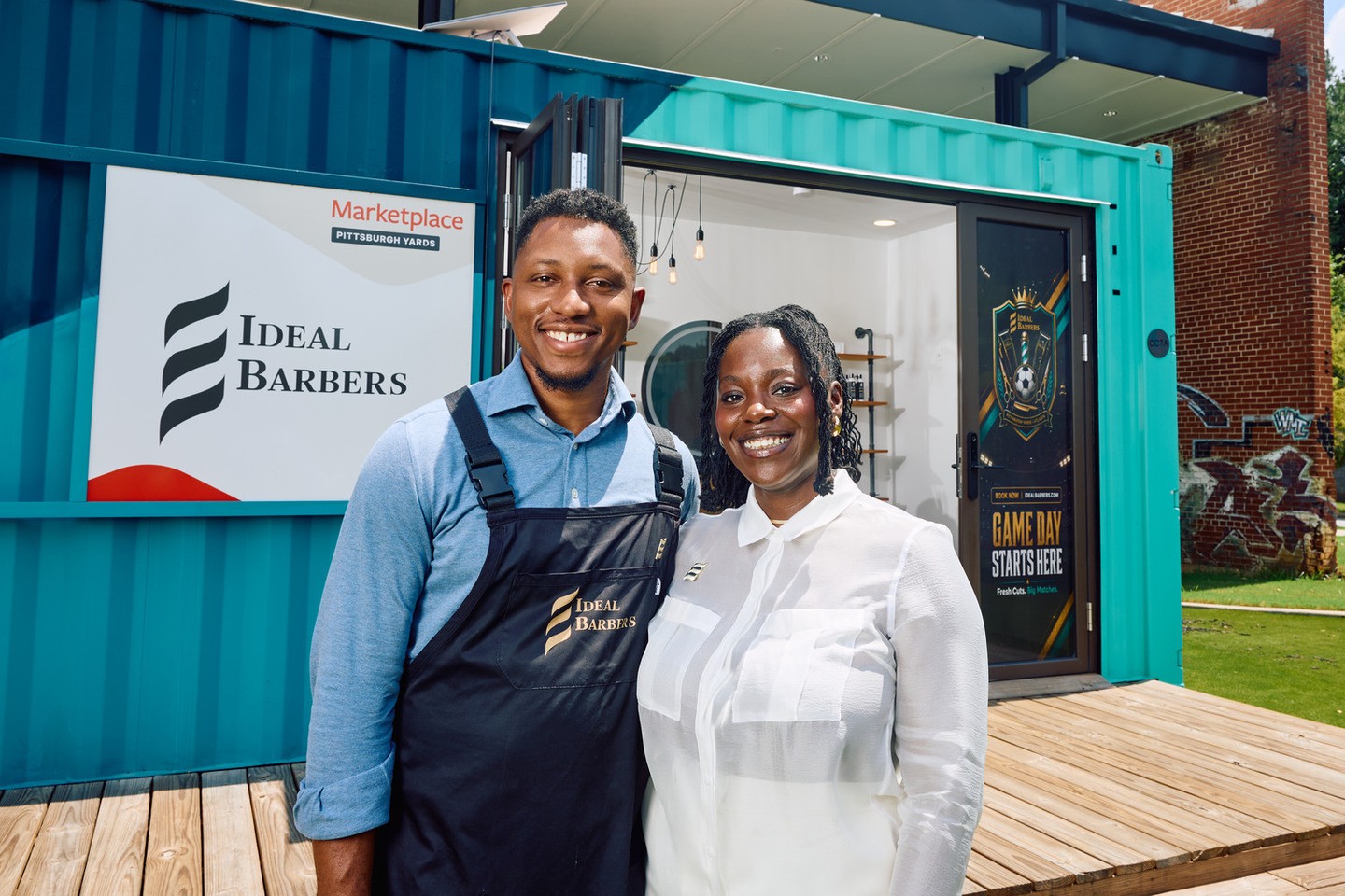 Mike and Chaunte Andrews outside the teal Ideal Barbers container at Pittsburgh Yards.